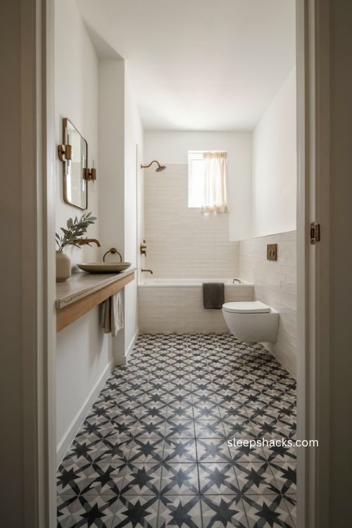 Small full bathroom with bold black and white patterned floor tile and simple walls 