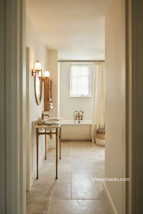 Small full bathroom with corner console sink open floor and wall mounted storage 