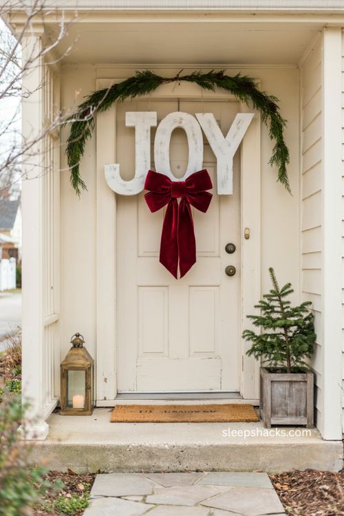 Small porch Christmas decor with bold joy sign and oversized red bow