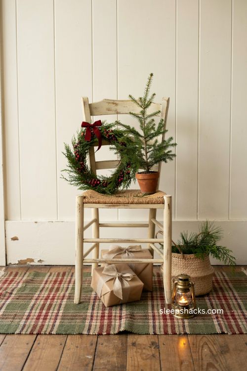 Small porch Christmas decor with chair vignette and cozy holiday tree 