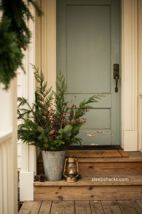 Small porch Christmas decor with galvanized bucket pine greenery and pinecones 