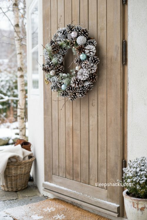 Snowy pinecone Christmas wreath with white paint and icy blue ornaments 
