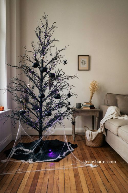 Spider web tree skirt with plastic spiders and purple lights on a black halloween tree 