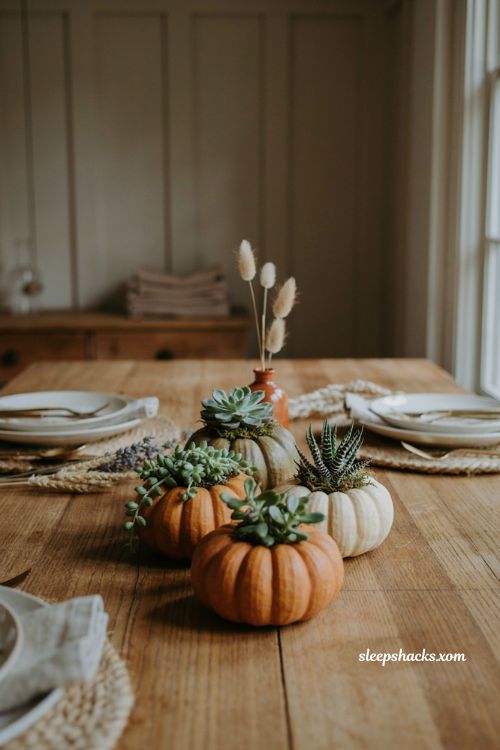Taper candle Thanksgiving table centerpiece with warm glowing candles and neutral linen decor
