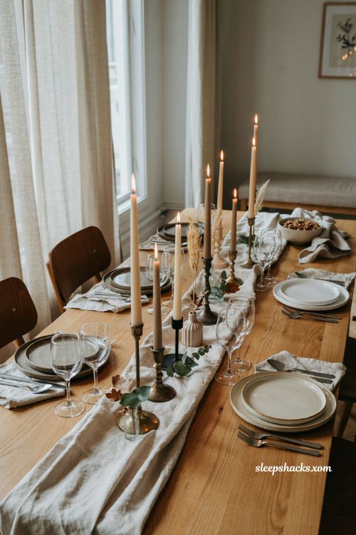 Taper candles and staggered candlesticks on a modern Thanksgiving table with brass and matte black holders

