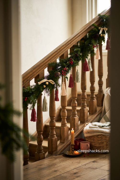 Tasseled Christmas garland on staircase with handmade paper decorations