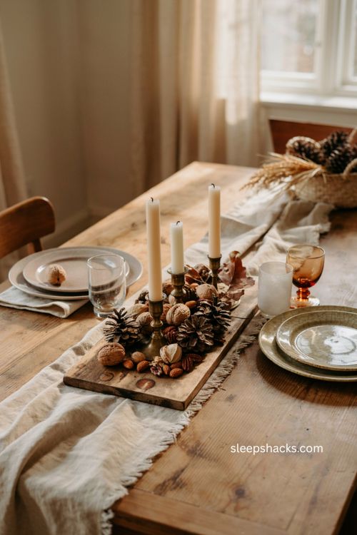 Thanksgiving centerpiece with pinecones nuts dried pods and candles 
