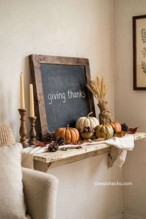 Thanksgiving chalkboard mantel vignette with pumpkins pinecones and dried wheat farmhouse decor 
