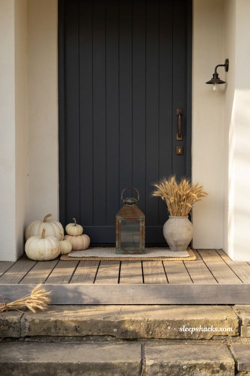 Thanksgiving front porch decor ideas with neutral pumpkins and wheat
