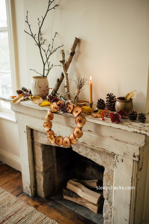 Thanksgiving mantel decor with foraged branches leaves pinecones berries and dried apple wreath 