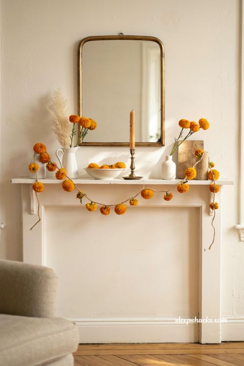 Thanksgiving mantle ideas with marigold garland and neutral decor
