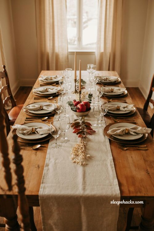 Thanksgiving table runner with gold chargers and coordinating napkin rings
