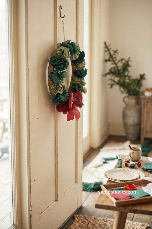 Tissue paper wreath Christmas craft for toddlers with green scrunched paper and red bow 
