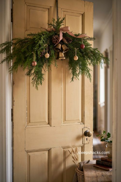 Vintage Christmas swag with antique bells wooden ornaments pinecones and faded ribbon
