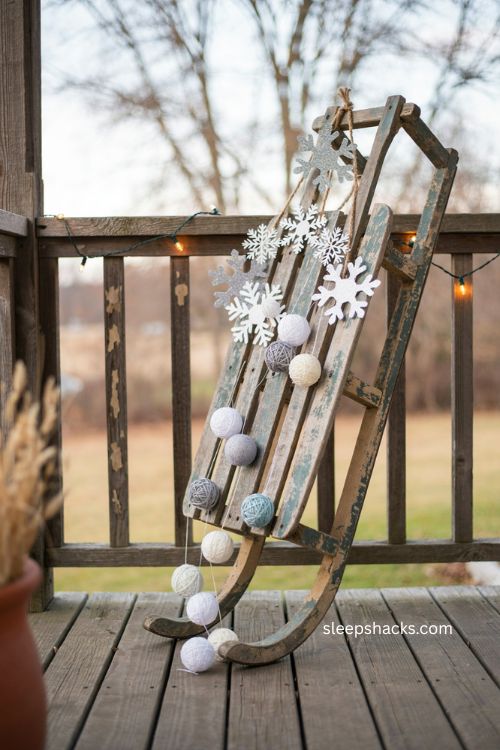 Vintage sled Christmas decor with snowflakes and yarn snowballs 