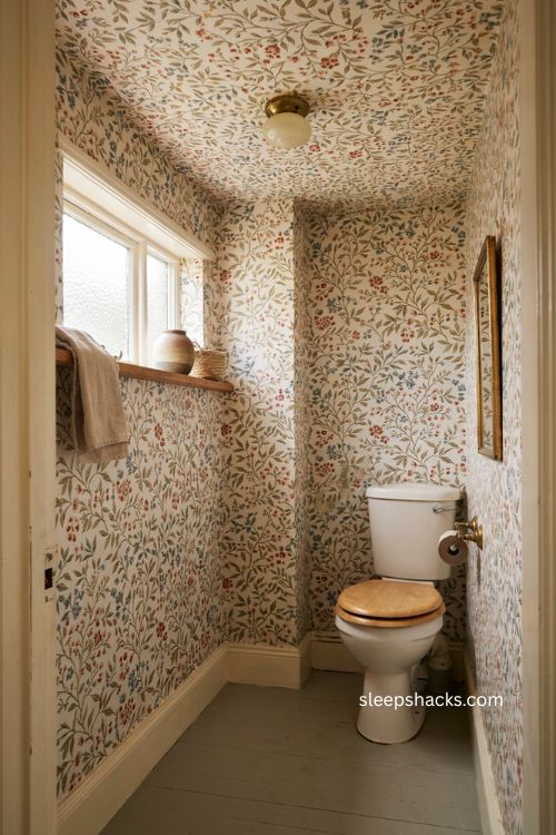 Water closet with botanical wallpaper on walls and ceiling for a cozy jewel box look