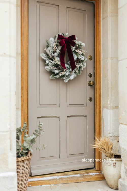 White Christmas wreath with bold burgundy velvet ribbon and bow 