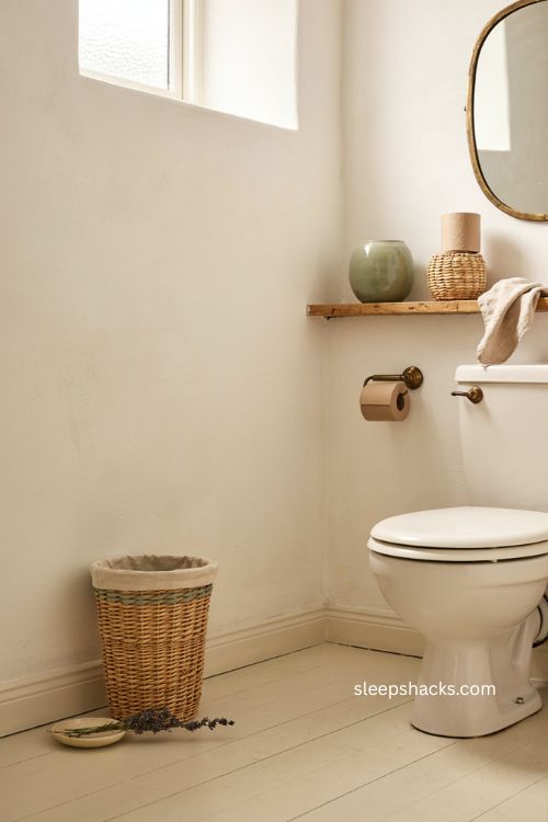 Wicker trash basket in a cozy water closet with sage green and vintage details