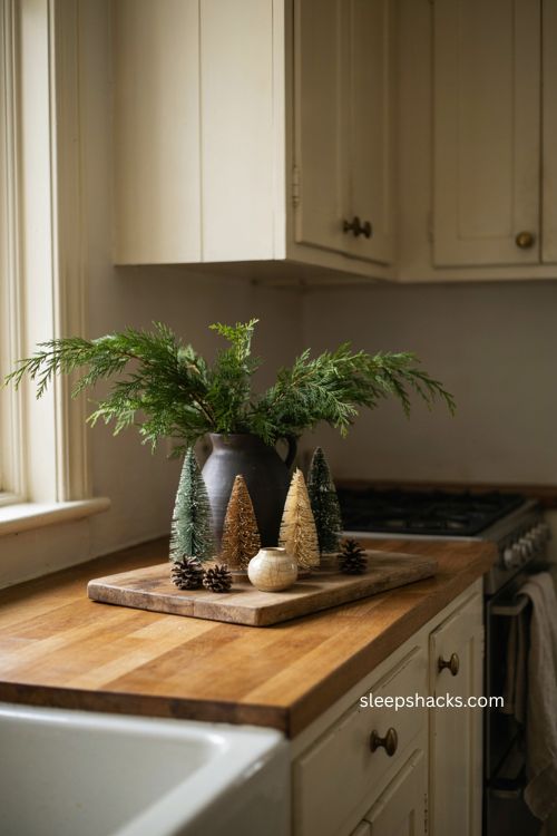 Wooden board Christmas kitchen counter vignette with greenery and bottlebrush trees 