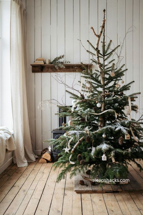 Woodland snowy Christmas tree with pinecones birch branches and white ornaments 