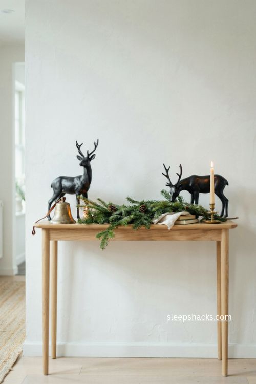 black and gold deer figurines christmas console table decor with evergreen garland 
