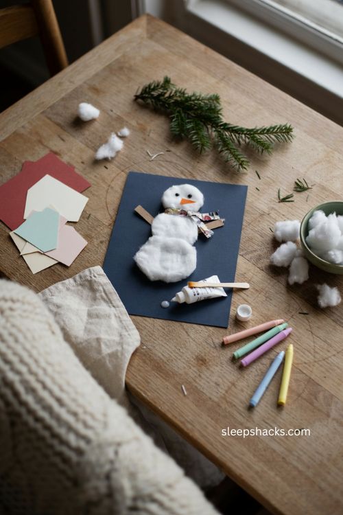 cotton ball snowman christmas craft for toddlers with fluffy texture colorful scarf and blue paper 