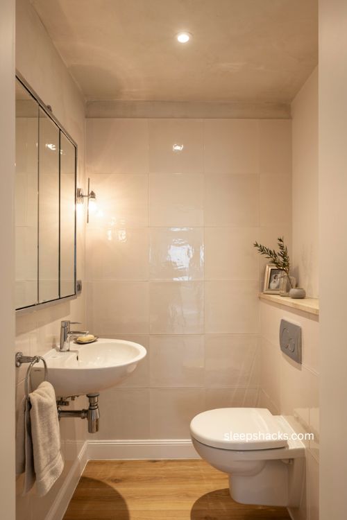 downstairs toilet ideas with reflective tiles mirrors and metallic details 