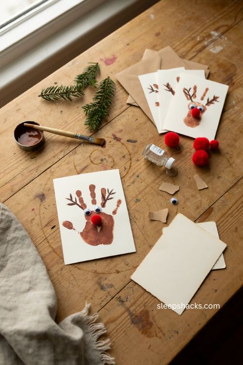 handprint reindeer christmas cards for toddlers with brown paint red pom pom noses and googly eyes 