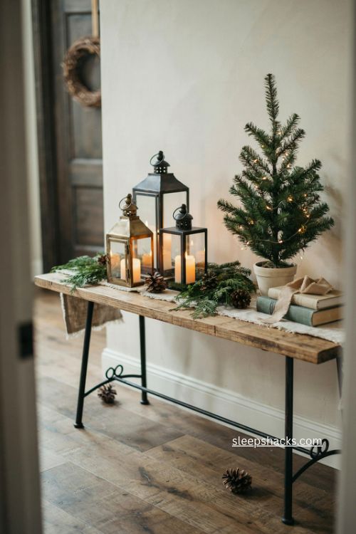 lanterns and candles christmas console table decor with evergreen and pinecones 