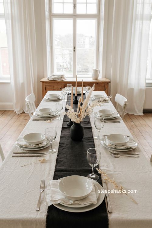 minimalist all white thanksgiving table with black accents and dried greenery