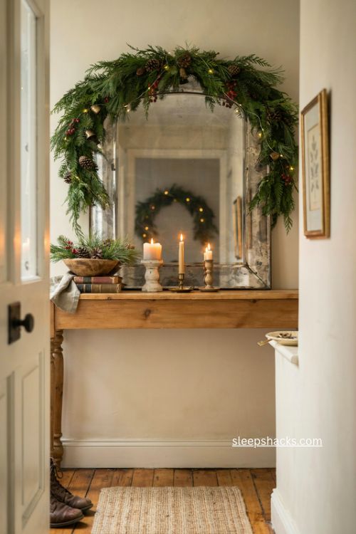 mirror with garland christmas console table decor cozy entryway with candles and greenery 