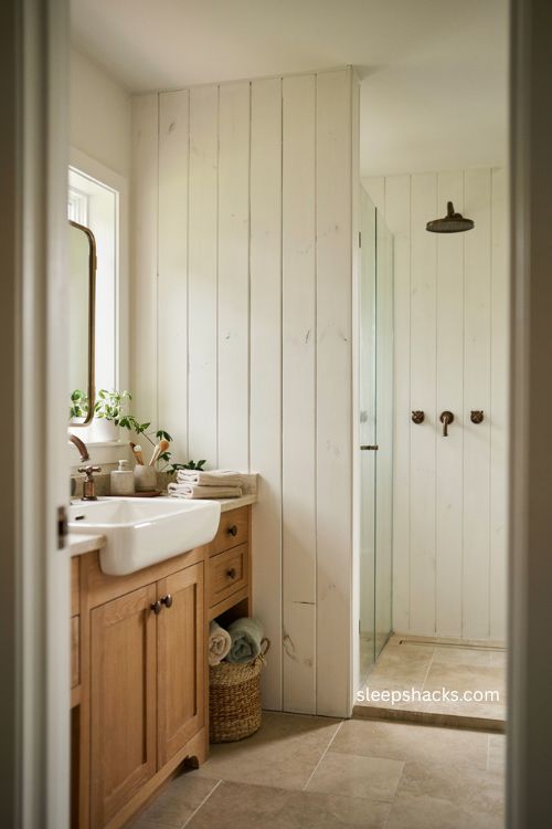 modern farmhouse bathroom with white shiplap walls and warm wood vanity 