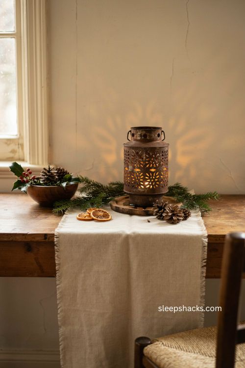 primitive Christmas punched tin lantern with warm colonial candlelight and evergreen decor 