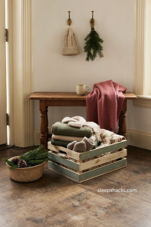 striped winter storage crate in cream and forest green with blankets mittens scarves and vintage quilt 