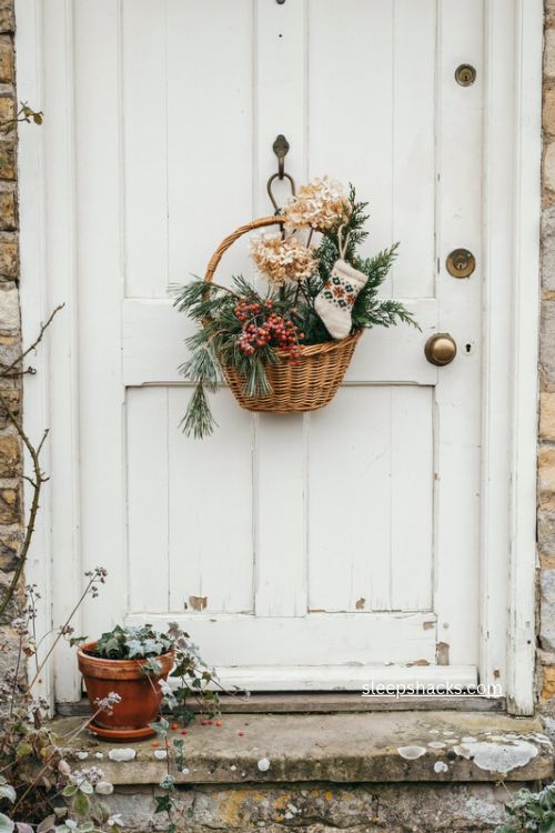 woven christmas door basket with evergreens juniper berries and dried hydrangeas 