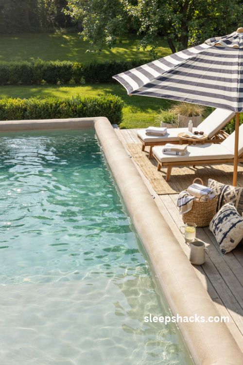 Adult inflatable pool with coastal sun loungers striped umbrella and beach club decor