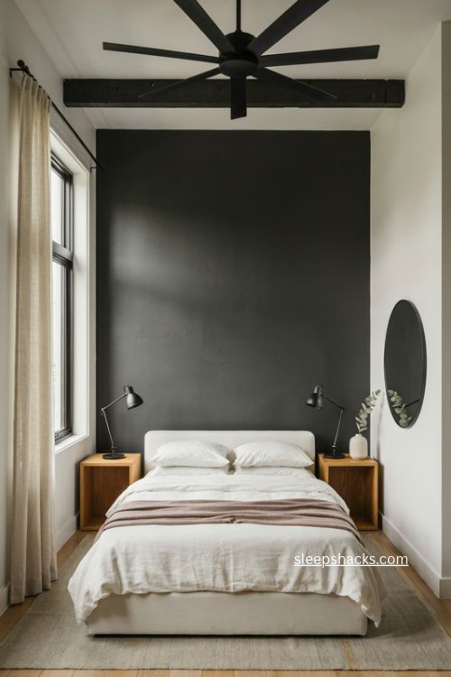 Airbnb guest bedroom with dramatic black accent wall white bed and industrial lighting