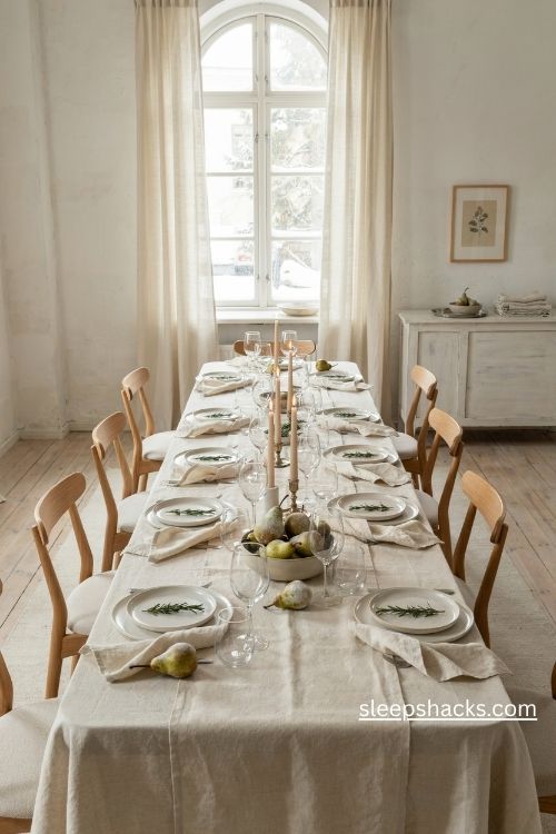 All white Christmas table setup with frosted pears linen napkins and pale candlelight