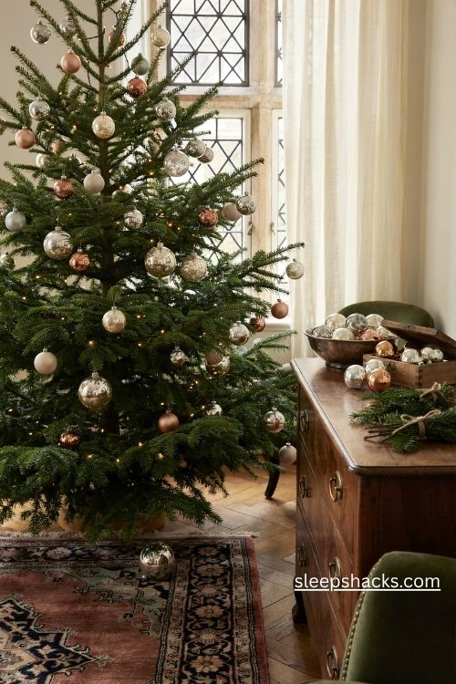 Antique mercury glass christmas ornaments in tarnished silver and gold on a nostalgic vintage tree