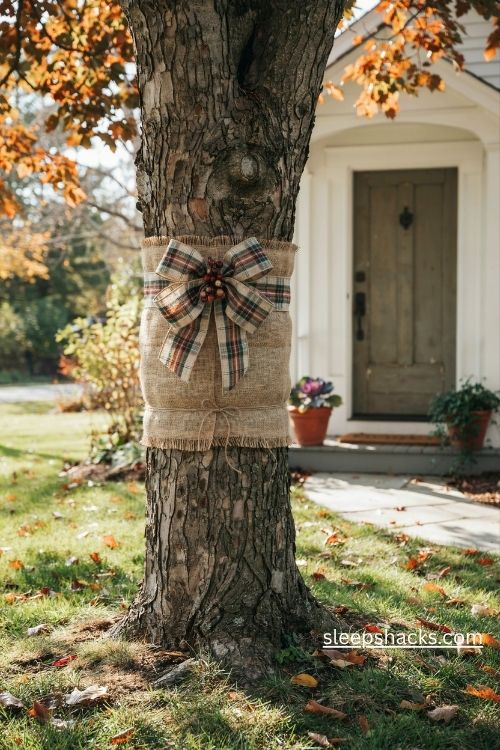 Burlap wrapped tree trunk with a rustic autumn plaid ribbon bow