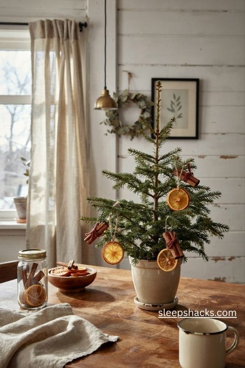 Charlie brown christmas tree with dried orange slice and cinnamon stick ornaments in a cozy farmhouse kitchen