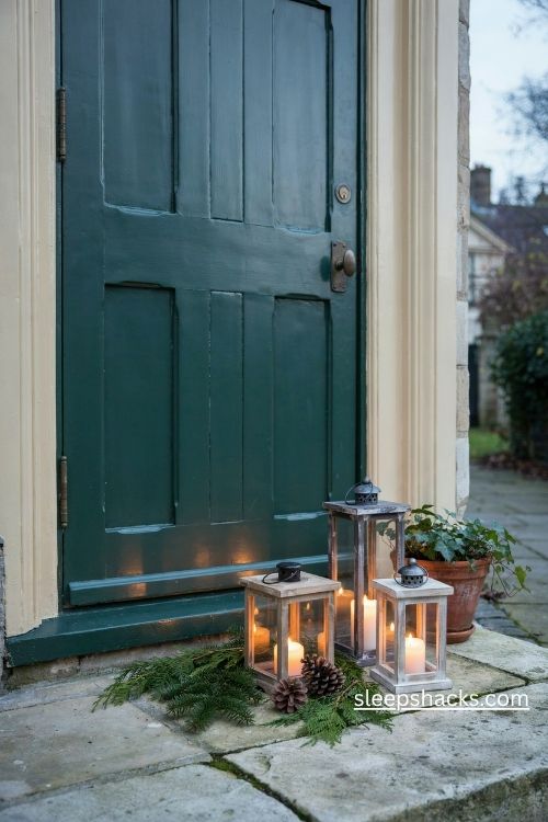 Christmas front porch lantern cluster with glowing candles evergreen sprigs and rustic pinecones