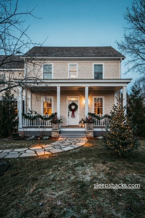 Christmas front yard with warm white pathway lights evergreen wreath and coordinated farmhouse holiday decorations
