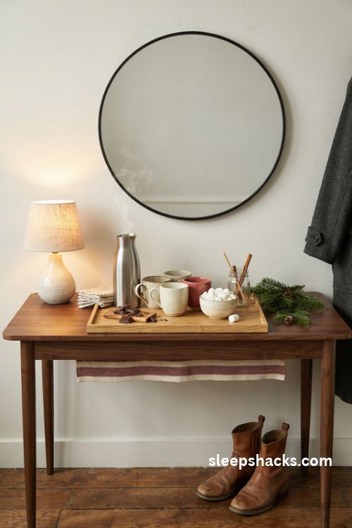 Christmas hot cocoa welcome tray with ceramic mugs marshmallows thermos and festive greenery on an entryway console