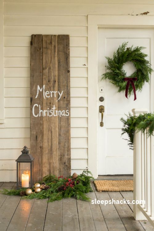 Christmas porch ideas with a rustic wooden Merry Christmas sign evergreen branches and lantern
