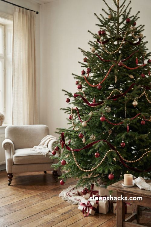 Christmas tree with layered red bead garlands burgundy velvet ribbon and gold accents