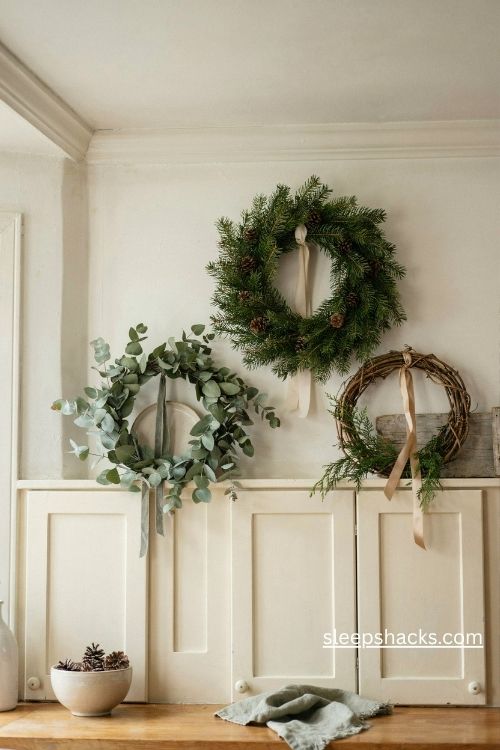 Christmas wreaths in eucalyptus pine and grapevine leaning above cream kitchen cabinets