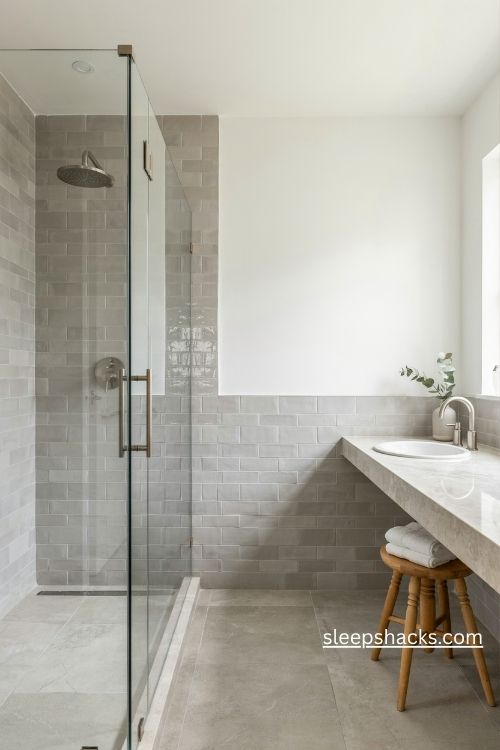 Classic grey subway tile bathroom with glossy shower walls and white fixtures 