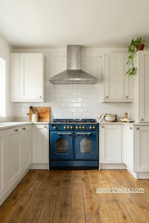 Cobalt blue range cooker with white kitchen cabinets and pale stone countertops