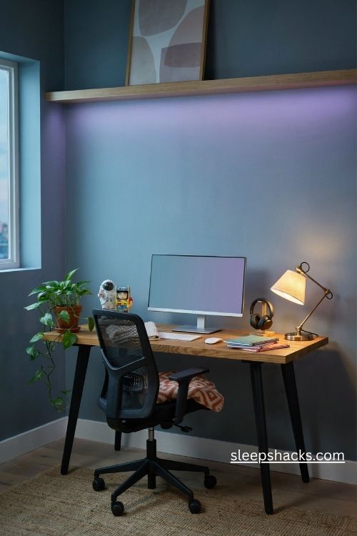 Color changing led strips in a funky home office with purple teal ambient lighting and a cozy gaming inspired desk 
